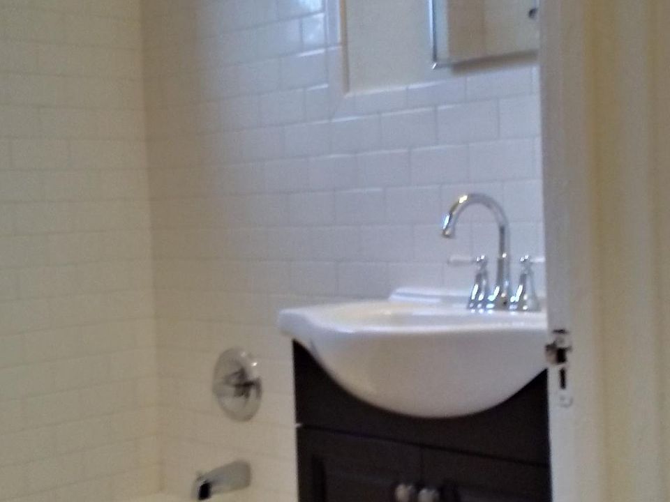 Remodeled bathroom in 1940s period style with subway tile and black and white checked floor tile