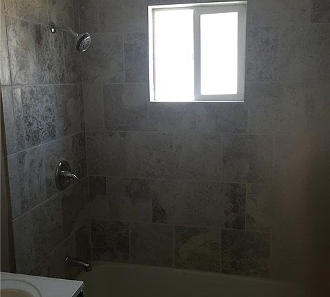 Bath with new tub/shower, new tile, new sink, new toilet, new tile flooring