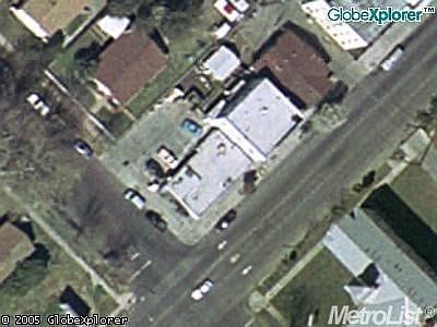aerial view of subject property. the white top roofs are the subject. to the left is the one story and to the right is the two story and to the top is garage/storage structure.