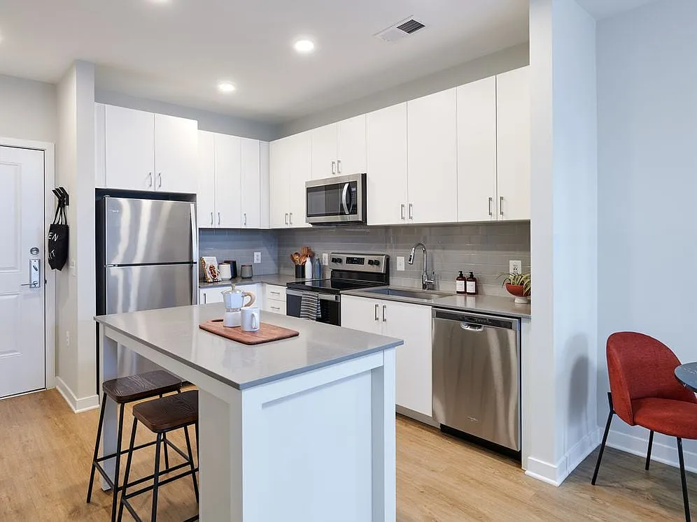 Design Collection II kitchen with white cabinetry, grey tile backsplash, grey quartz countertops, and stainless steel appliances - Avalon Foundry Row