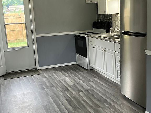 Kitchen (all electric) . Backdoor leading into the fenced back yard.