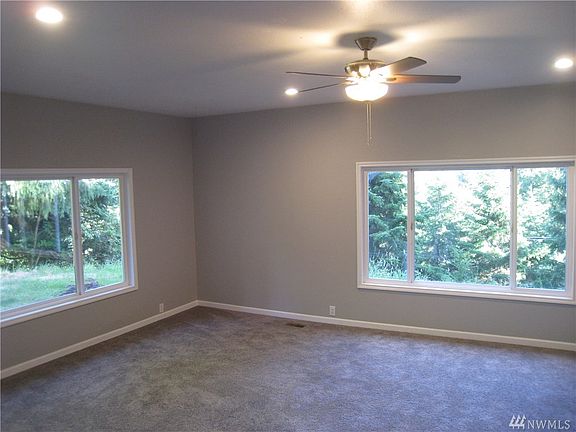 Living Room with fan and large windows to let the light in!