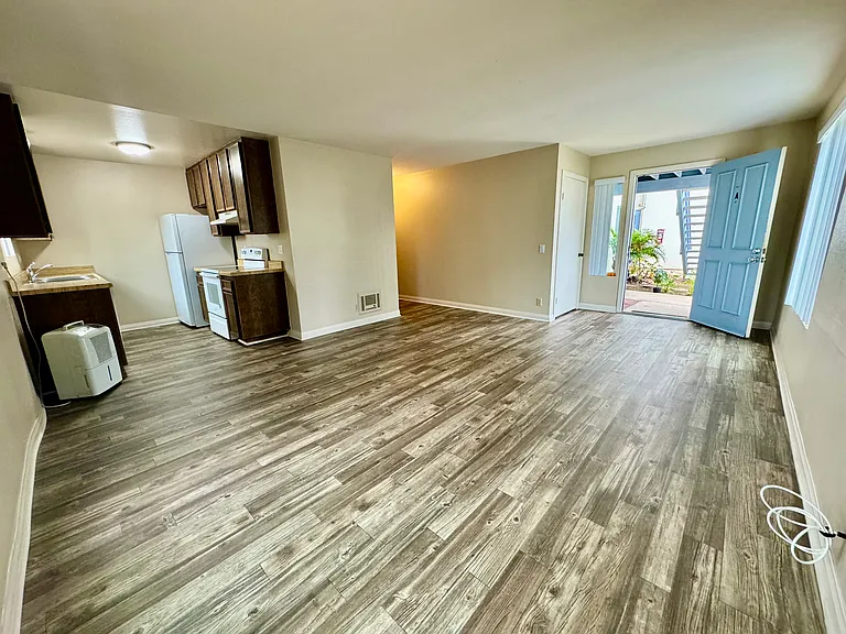 View from living room into kitchen and front door with entrance closet