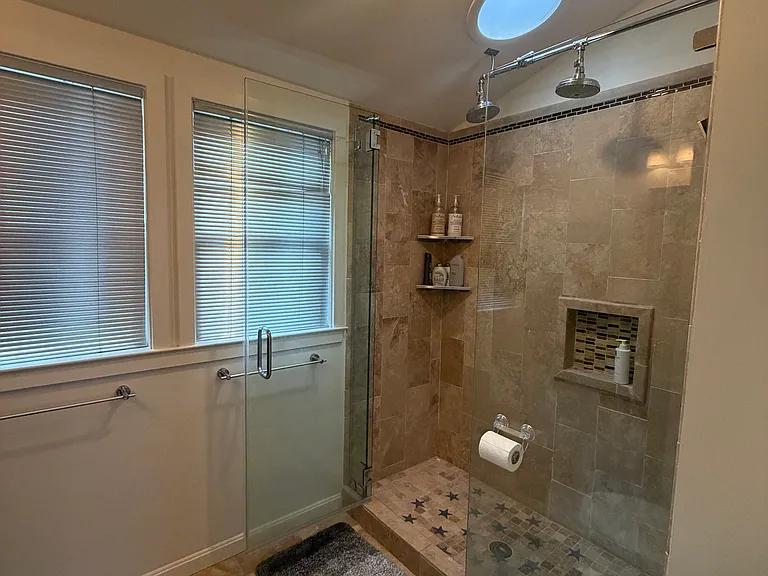 Shower features two showerheads, a skylight, and dedicated heater