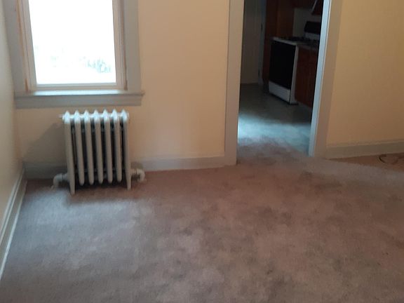 Separate, large dining room has a large window and leads to the kitchen.