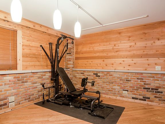 SOLID HARDWOOD AND WARM BRICK GRACE THE LOWER FAMILYROOM