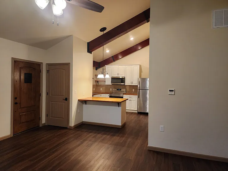 Livingroom standing at opposite corner from front door. Front door, coat closet door seen in photo, view of kitchen
