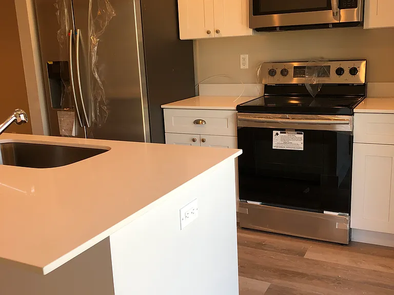 Kitchen - island stove, fridge and microwave.