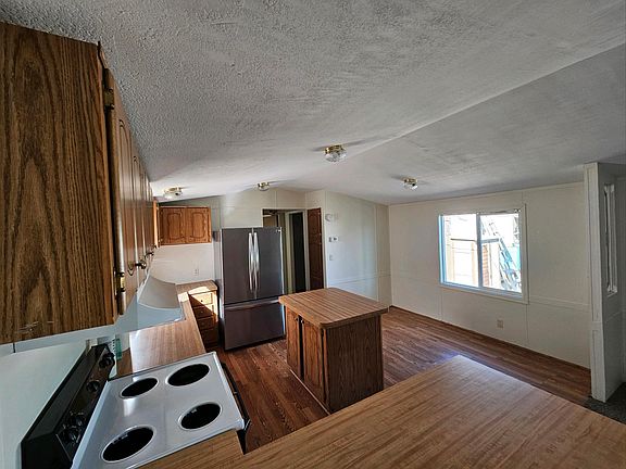 Kitchen with dining area on right side of photo by window