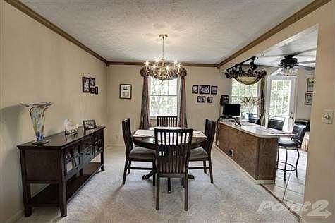 This cheerful yet elegant dining room offers crown molding, a single view window overlooking the parklike backyard and a full view of the kitchen with counterbar.