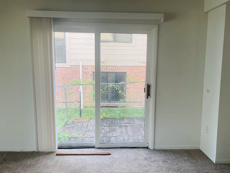 Sliding door from the living room out to the fenced side yard. There is a small deck where you could put a table and chairs.
