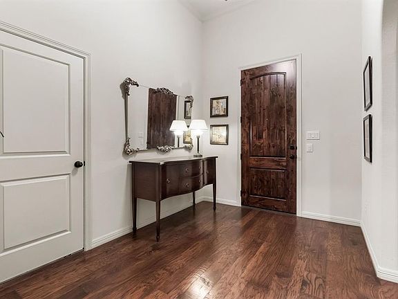 Entryway with 12 foot mahogany door. The white door leads to the 2 car garage.