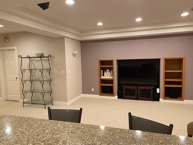 Living room with large TV with surround sound included.