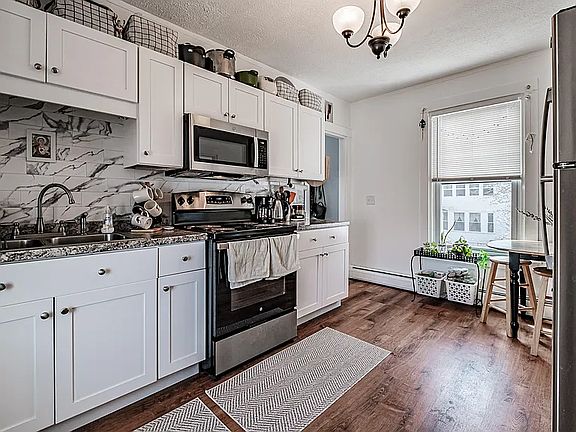 Updated kitchen with new cabinets, counters and stainless steel appliances. Open and bright, with windows on both ends.