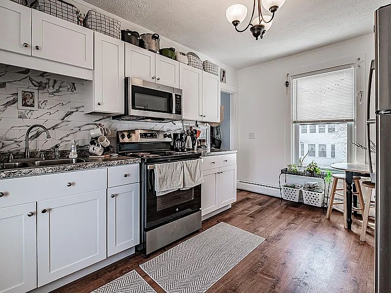 Updated kitchen with new cabinets, counters and stainless steel appliances. Open and bright, with windows on both ends.