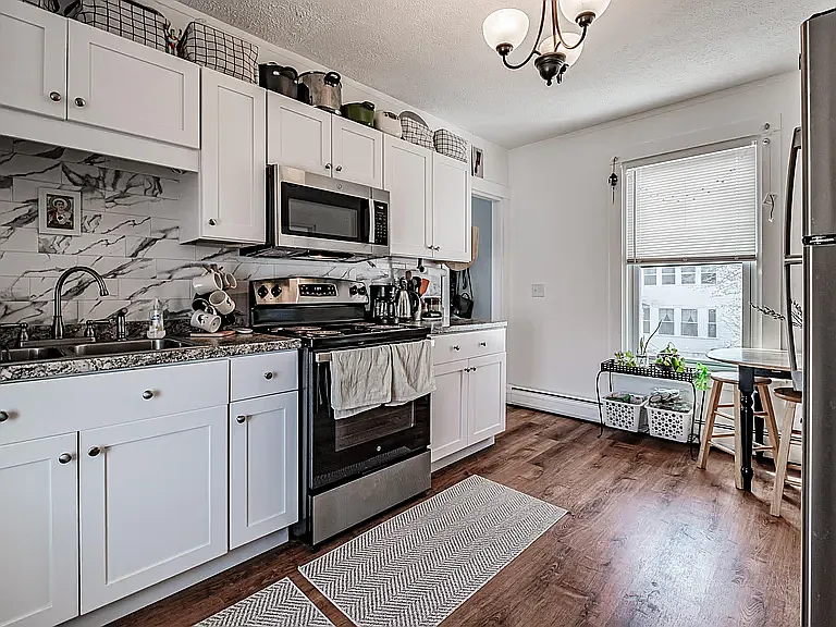 Updated kitchen with new cabinets, counters and stainless steel appliances. Open and bright, with windows on both ends.