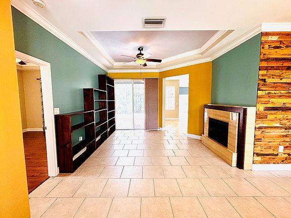 View from front door into living room with cozy electric fireplace. Dining room off to right.