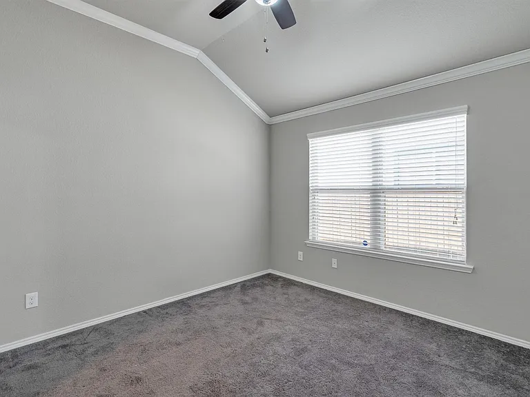 Room featuring a vaulted ceiling and a ceiling fan