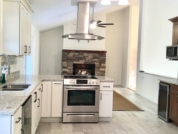 Kitchen with beverage cooler and fireplace view tile floors.