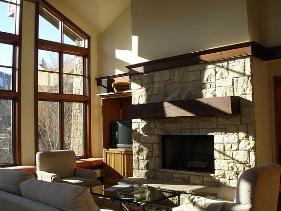 Sunny great room with vaulted ceiling and stone fireplace