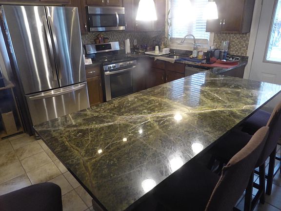 Granite counters with eat-in kitchen and stainless steel appliances
