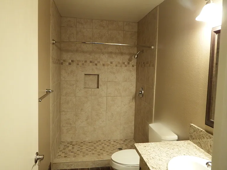 Master bath with large walk-in tiled shower with chrome details.