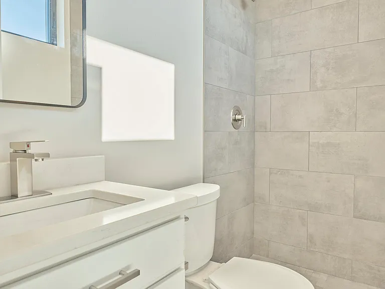 2nd bedrooms private bathroom with tile shower.