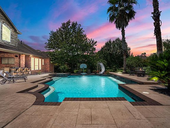 Amazing outdoor kitchen including a fireplace, multi-level decking, raised spa, outdoor speakers, spacious park-like backyard.