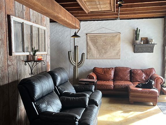 Rustic living room with waterfront views from two patio doors, gas fireplace and large smart tv.