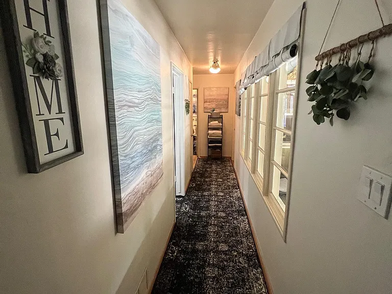 Hallway to bedrooms with patio windows