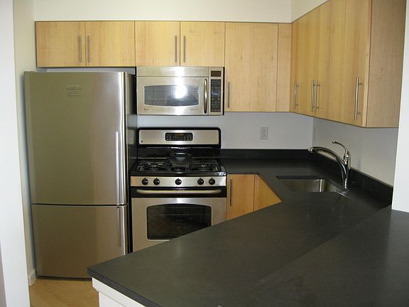 Kitchen with stainless steel appliances. Refrigerator, microwave, gas range and dishwasher.