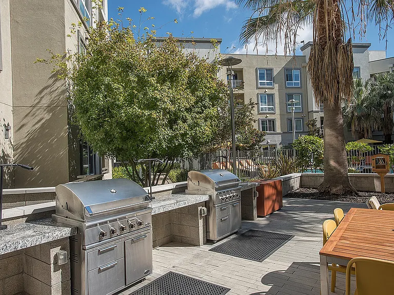 Fully equipped BBQ area with stainless-steel grills and shaded tables at Aster Apartments in Dublin, CA.