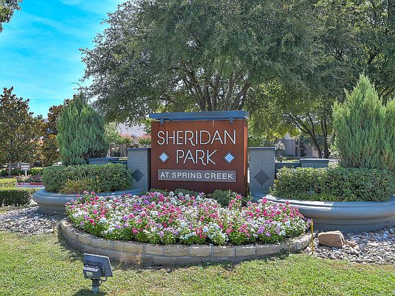 Front entrance monument sign with beautiful flowers in a flower bed.