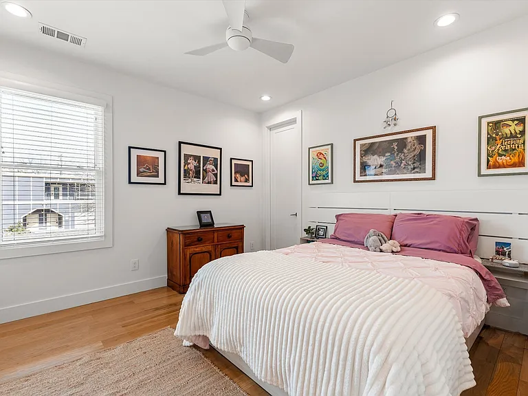 Secondary bedroom with hardwood floors and abundant natural light.