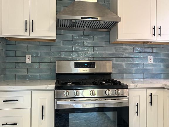 Gas stove, stone countertops and tile backsplash