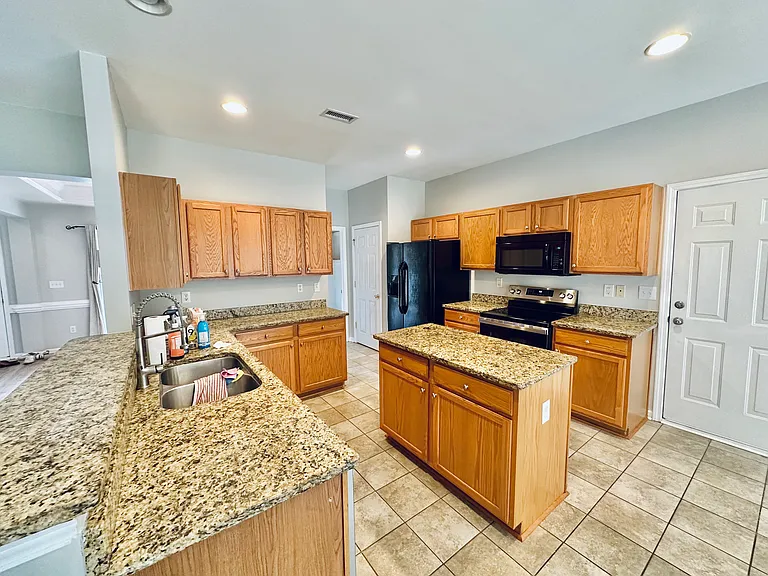 Kitchen with ample oak cabinets, bar sized counter and separate island.