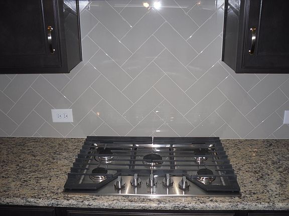 Gourmet gas 5- burner cooktop, Granite, Grey herringbone backsplash