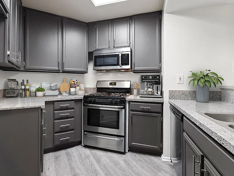 Stone tiled kitchen with stainless steel oven, microwave, and fixtures.