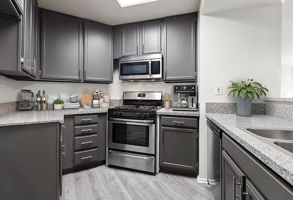 Stone tiled kitchen with stainless steel oven, microwave, and fixtures.