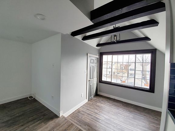view towards entry door and breakfast nook with large window and exposed beams