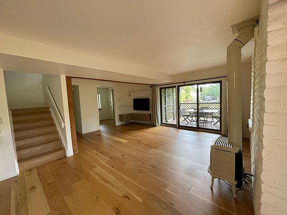View from the dining area. Just past the deck is the east side of the yard, with lawn and flowers. A small field maintained by the city lies on the other side of the fence, and if you're standing in the kitchen, you're looking at this and, further on, peo