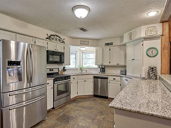 Updated kitchen with tastefully painted cabinets, granite countertops, stainless appliances, and attractive hardware.