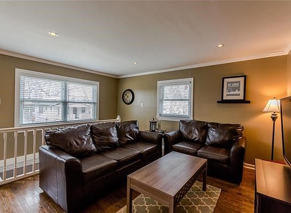 Open floorplan - living space and stairs to lower level behind couch.
