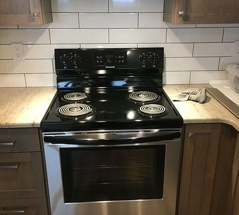 Range and Hood Vent. Subway tile backsplash.