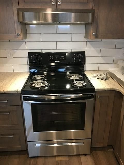 Range and Hood Vent. Subway tile backsplash.