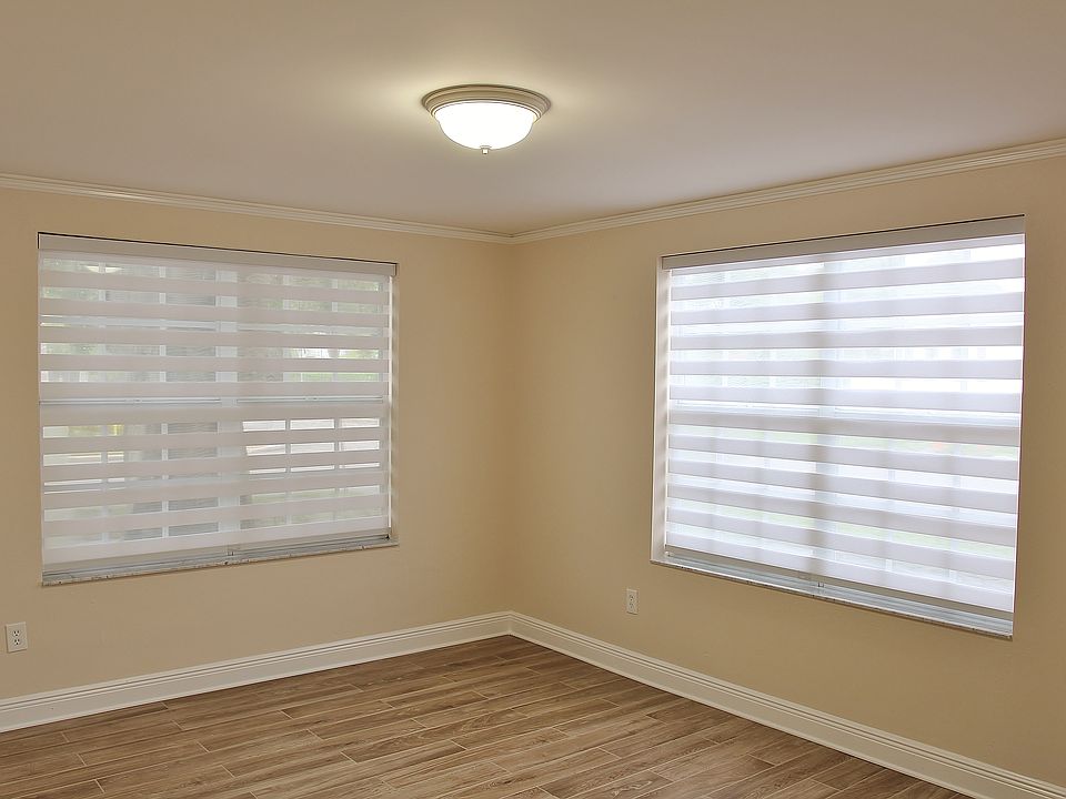 Spacious Corner View Living Room Featuring Zebra Blinds For "Light-In" Privacy.