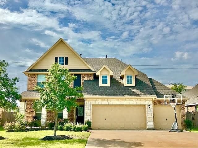Evergreen offers a stone and brick elevation with a 3 car garage and a cozy porch.