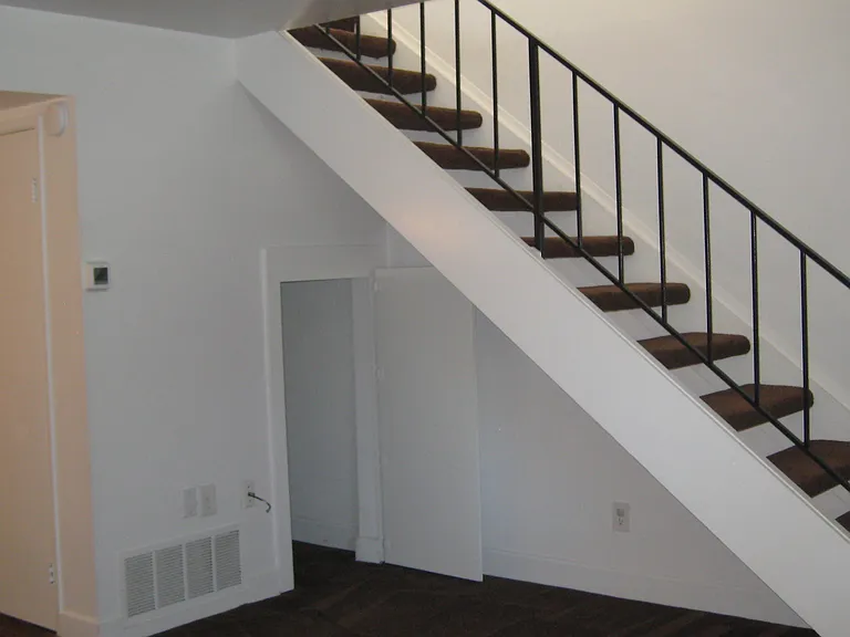 Steps to upstairs bedrooms. Also good size storage room under steps with door.