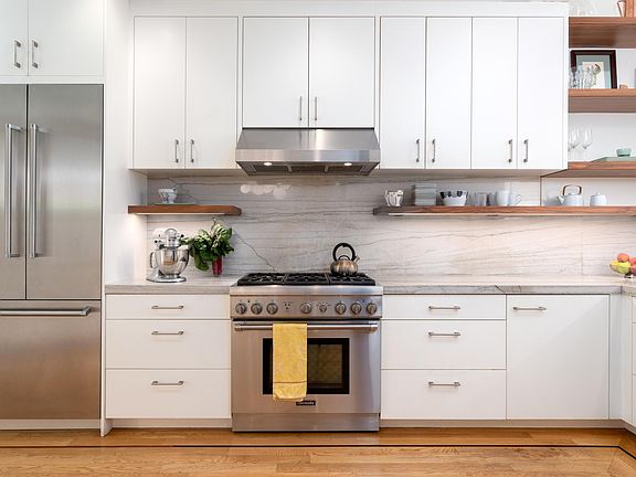 Custom American walnut floating shelves in kitchen.