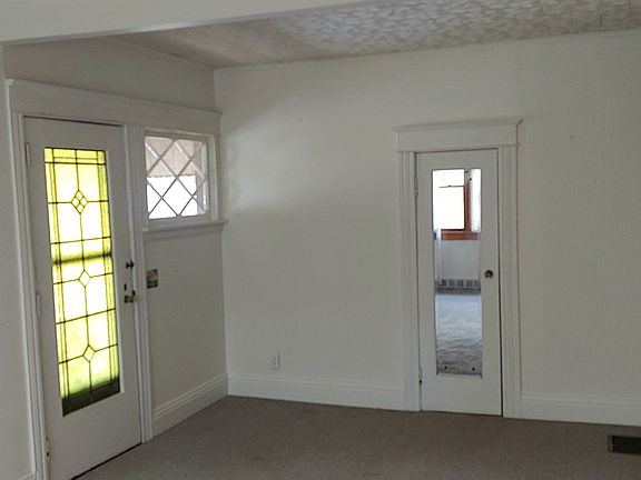 Other end of living room. Custom leaded glass front door. Classic mulled secondary light window and coat closet New carpeting just installed.